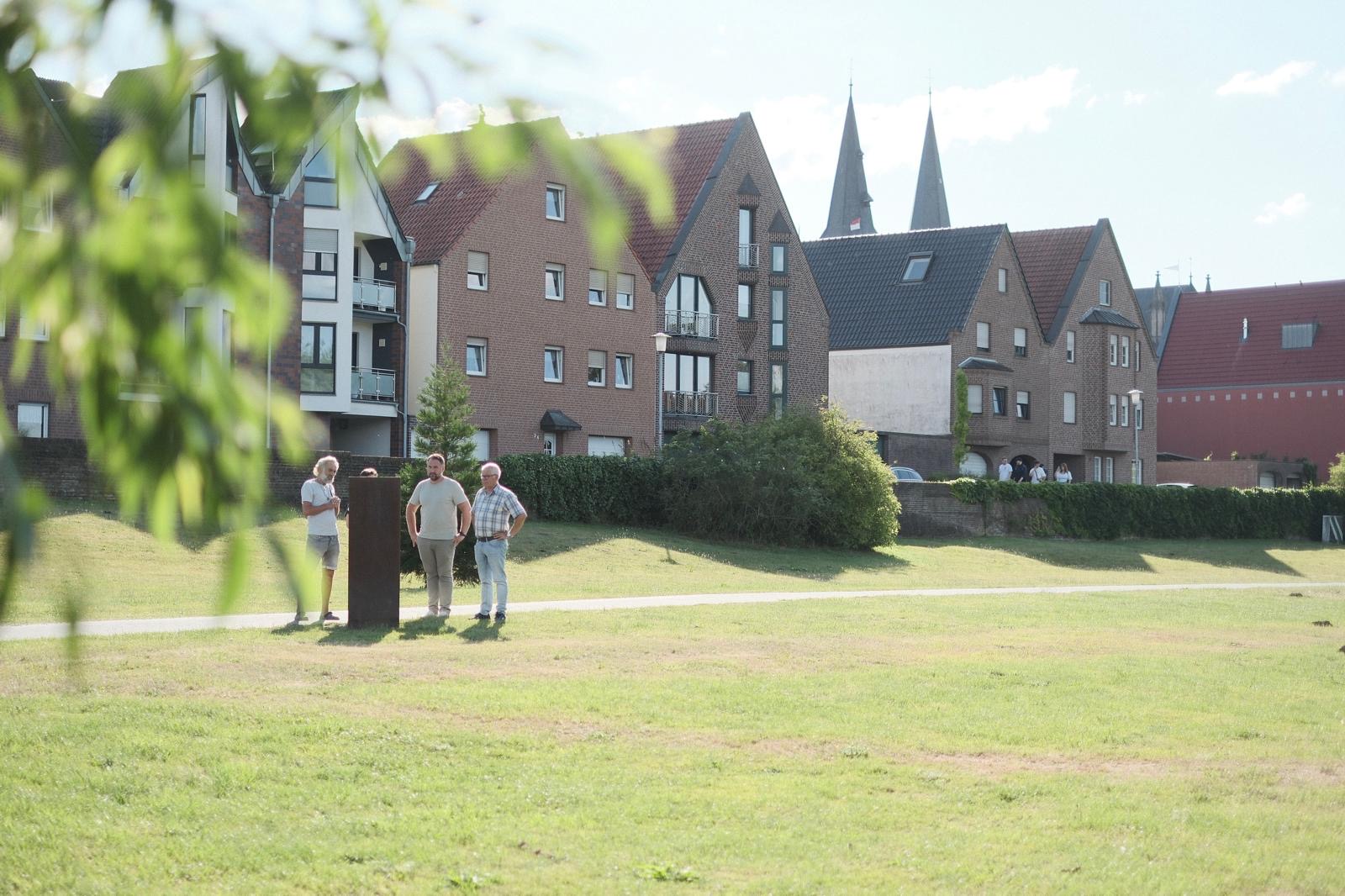 Bild im Kurpark Xanten am Kunstwerk mit Häusern im Hintergrund
